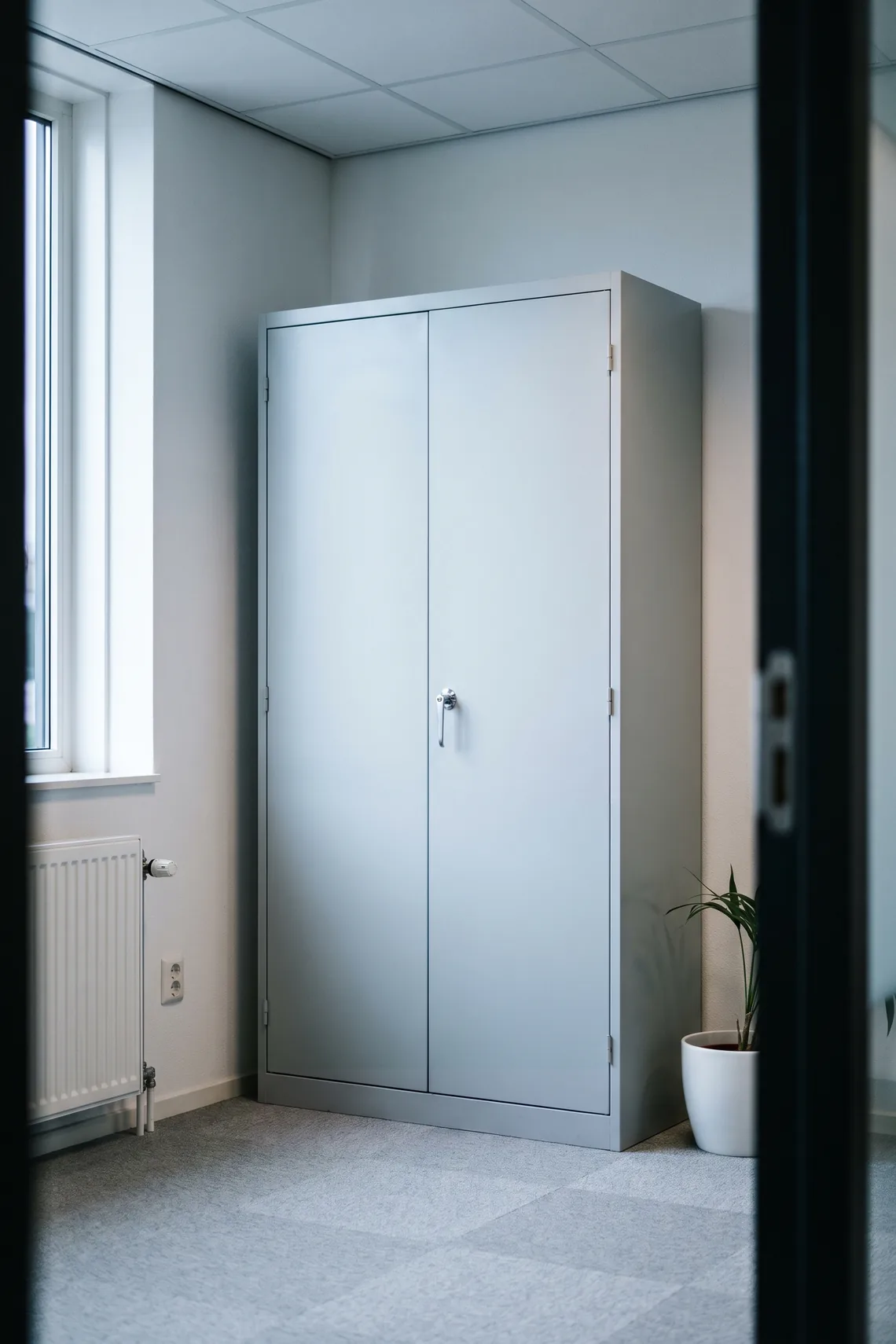 Een dichte metalen archiefkast met slot in een kantoor.