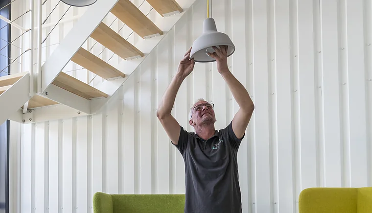 Verhuizer van Top Movers monteert een hanglamp