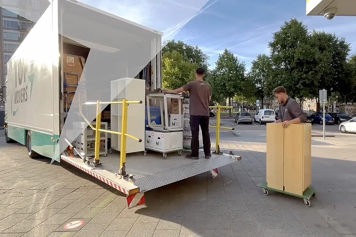 Twee verhuizers van Top Movers rijden een kast op een meubelhondje bij de laadklep van de verhuiswagen