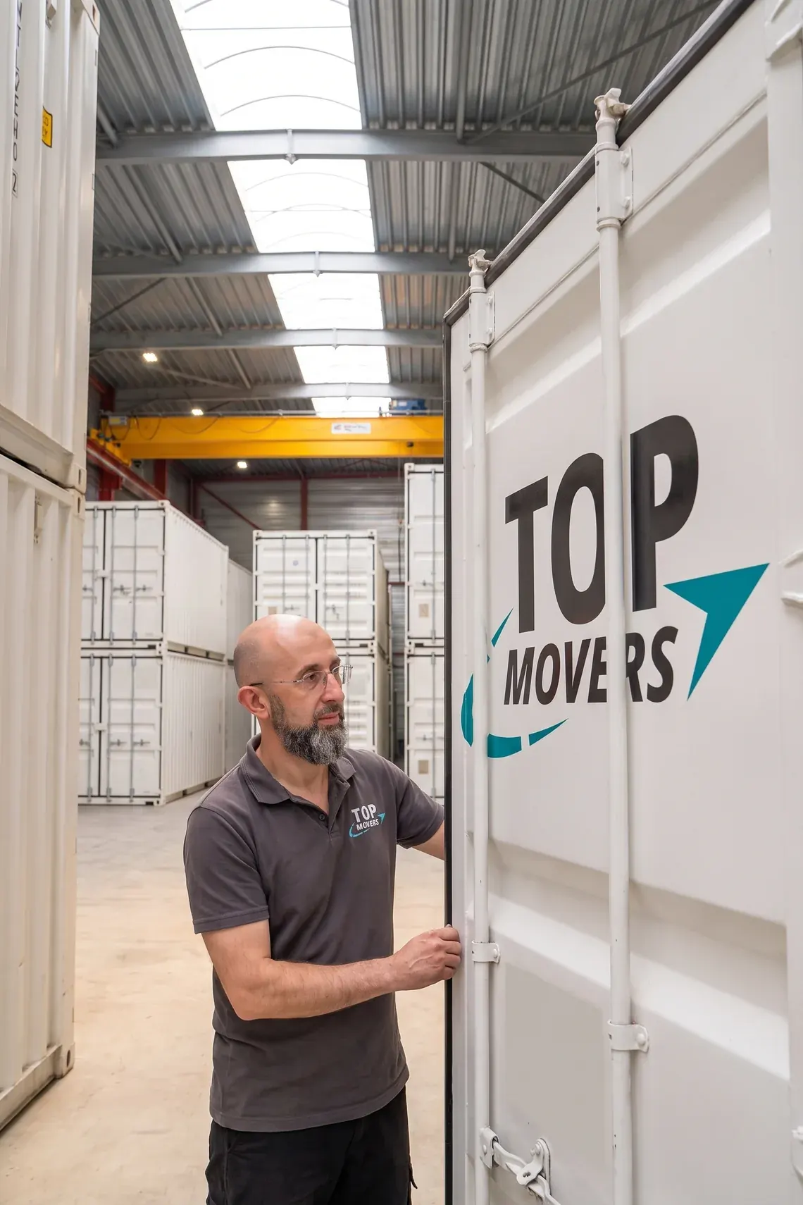 Verhuizer sluit de deuren van een witte opslagcontainer in de loods