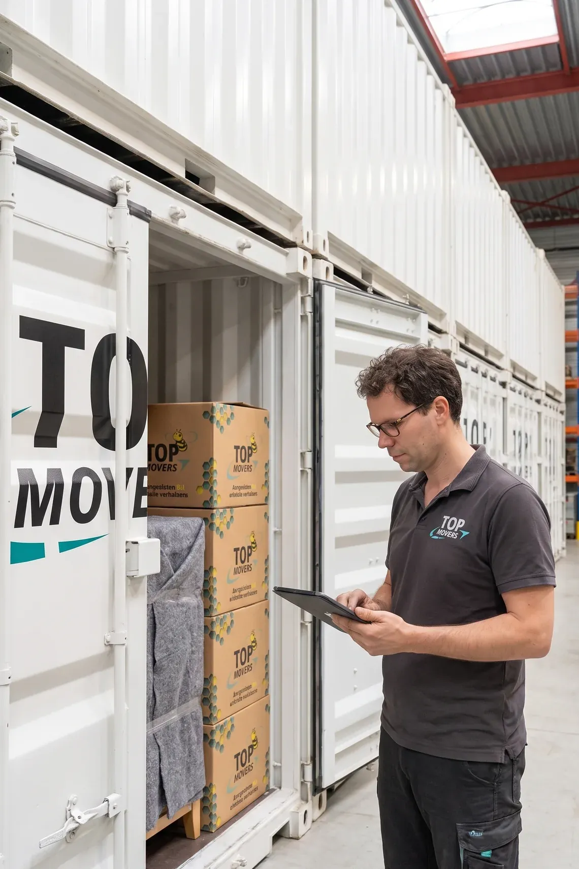 Verhuizer neemt met een tablet de inhoud van een opslagcontainer op