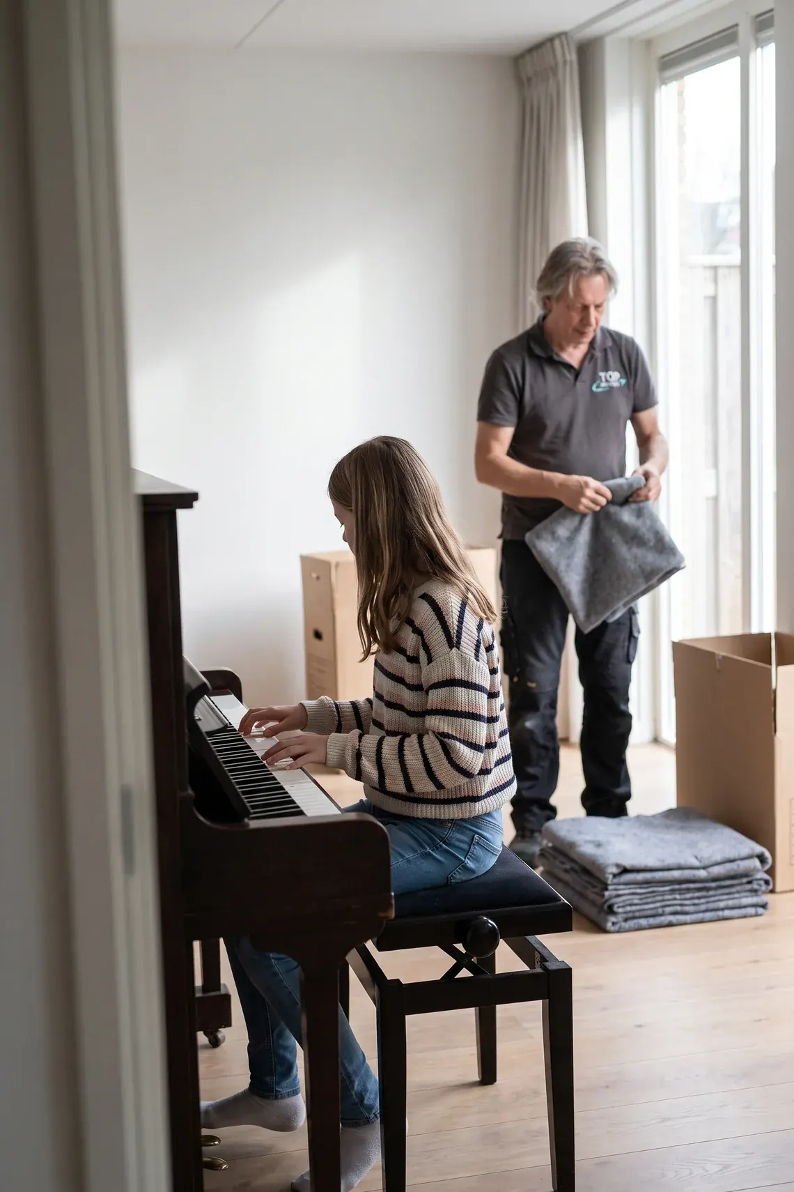 Meisje speelt de eerste noten op de piano in de nieuwe woonkamer